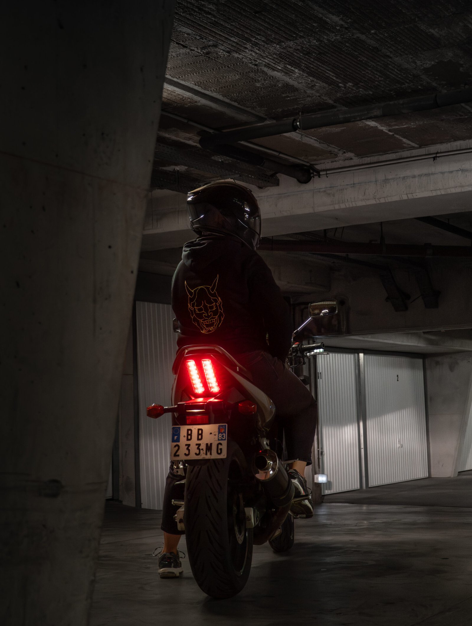 Motard en blouson cuir dans un garage industriel à Marseille